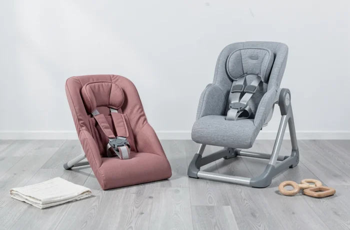Comparaison côte à côte d'un transat bas inclinable rose et d'un transat haut gris structuré sur un sol gris dans un intérieur épuré