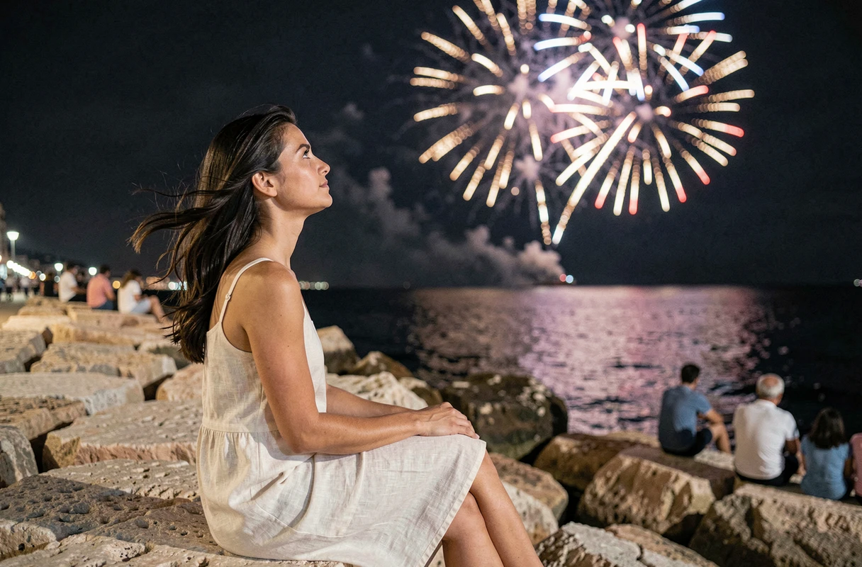 Jeune femme admirant le feu d'artifice du 14 juillet depuis les rochers de la Corniche à Marseille